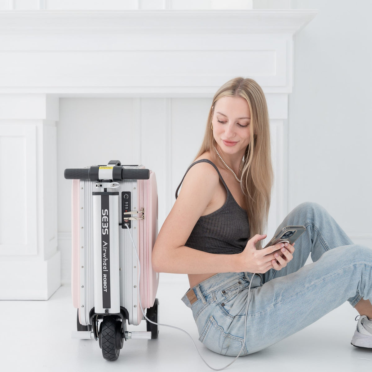 Frau lädt ihr Handy über den USB-Ladeport des Airwheel SE3SL in Pink